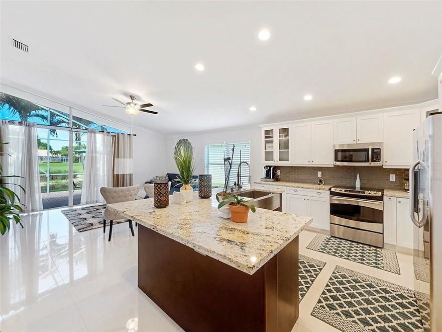 Impeccably upgraded home in the sought after golf community of Atlantic National. This amazing home features stainless steel appliances, granite counter-tops with glass subway tile backsplash, slow close wood cabinets, huge 24x24 porcelain tile floors, crown molding, frameless shower doors, 2015 roof, and a 2016 A/C .The screened patio overlooks a lake & golf course. Atlantic National is a 24hr guard gated golf-community that includes cable, landscaping, & many more amenities with no mandatory golf dues.