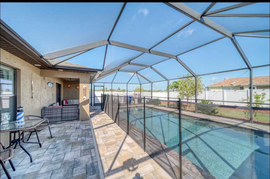 Discover this charming single-family home built in 2018, perfectly situated in desirable Southwest Cape Coral. Offering 3 bedrooms, 2 bathrooms, and 1,522 square feet of living space, this well-maintained residence features an open and inviting floor plan with stylish finishes throughout. Step inside to a seamless flow from the bright living area into the dining space and a well-appointed kitchen complete with a breakfast bar, kitchen island, and pantry—ideal for everyday living and entertaining. The split-bedroom layout provides privacy, while tile and carpet flooring, ceiling fans, and central air keep the home comfortable year-round. A 2-car attached garage adds convenience and storage.  Outside, enjoy your private Florida oasis with a large in-ground pool and spacious patio area perfect for lounging, grilling, or relaxing in the sun. The fully fenced backyard ensures privacy and is ideal for families, kids, or pets. Additional highlights include a screened porch/lanai, manual shutters, and excellent curb appeal. Located on a generous 0.24-acre lot between Pine Island Road and Veterans Parkway, this home offers easy access to shopping, dining, schools, parks, and all the amenities Cape Coral has to offer. No HOA fees make it even more appealing. Whether you're looking for a move-in-ready home or a relaxing retreat, this 2018-built gem is ready for you. Schedule your private showing today!