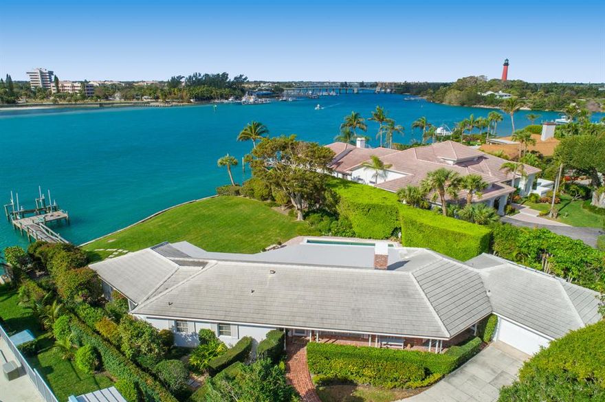 One of the premier waterfront homesite on the east coast of FL directly on the blue water where the Jupiter Inlet meets the Intracoastal waterway overlooking the historic Jupiter Lighthouse. This charming single-story home on spectacular point lot, features panoramic views of Jupiter Inlet and Intracoastal Waterway, including Jupiter Lighthouse. Spacious floor plan includes 4 bedrooms, 3 bathrooms, 2 car garage and large kitchen with custom cabinetry overlooking the private pool, yard and dock with boat lift. 4th bedroom is small and can also be used as a den.