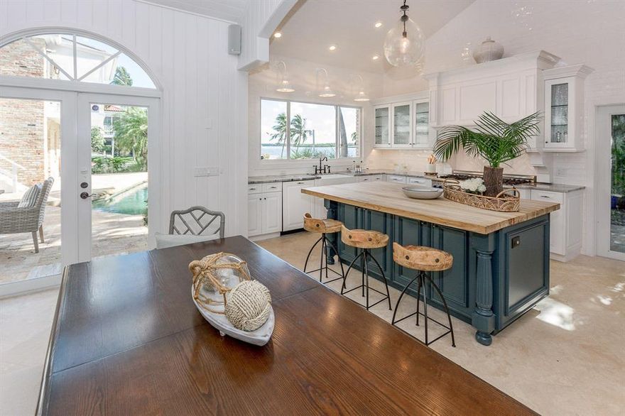 A true Caribbean island house!! Located in prestigious Mariners Key and surrounded by other large waterfront homes. Character and charm abound at this stunning 5 bedroom (plus den!), 4.5 bath waterfront home. These aren't just any water views, these are unobstructed wide channel views. This is navigable waterfront at its very best!! 151' of frontage with easy water access to great restaurants and nearby inlets.Impressive front door and gracious foyer entry leaves a lasting impression. Understated, luxurious interiors are a welcoming invitation to sit down in comfort and enjoy the scenic views. Spacious kitchen with solid wood cabinetry, butcher block island and professional series appliances. Giant picture window and handmade subway tiles adorn the walls from floor to ceiling -