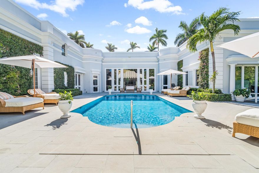 Regally elevated on over half acre this very proper Palm Beach residence showcases quintessential Palladian architecture set within beautifully landscaped pool gardens. Featuring hallmarks such as symmetry and proportion, the home offers very generous room sizes, ceiling heights, floor to ceiling windows and doors, an abundance of natural light from the many skylights throughout the home. Formal living and dining rooms are balanced with warm, inviting family gathering areas and spacious guest suites and quiet, lovely views from every window. Perfectly manicured landscaping envelopes the home, and the cabana with full guest suite anchors the north side of the grand heated swimming pool. A 3-car attached garage and plenty of driveway parking completes this wonderful north end offering.