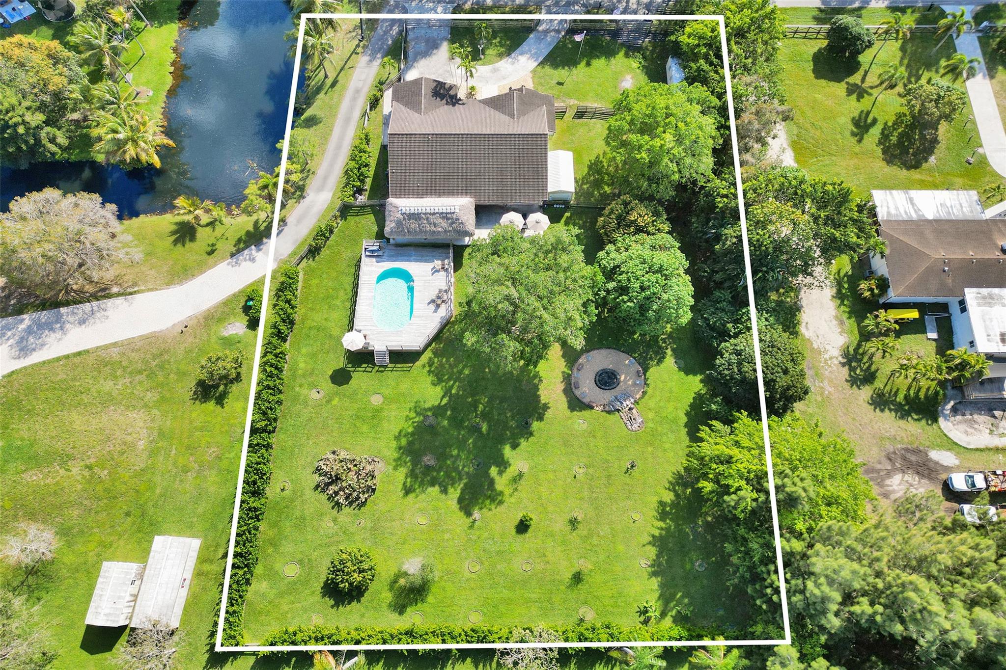 Discover the ultimate blend of luxury & privacy in this fully renovated home w/ 4 beds, 3 full baths + bonus 5th BR/office, set on a sprawling 1.11-acre lot at the end of a cul-de-sac with exclusive canal access. The outdoor space is an entertainer's dream, featuring a pool enclosed by spacious deck, oversized 17x30 tiki hut & 8’ fire pit. Fully fenced yard with privacy hedge & fruit trees. Driveway w/ space for 10 cars. The modern kitchen boasts lacquer cabinets, quartz counters & backsplash. High ceilings throughout. Spacious primary BR w/3 closets. Laminate wood floors throughout, impact windows & doors, full alarm & camera system. Laundry room w/ Maytag W/D, cabinets, large counters and double stainless sink. Property has no HOA and is within walking distance to top A-rated schools.