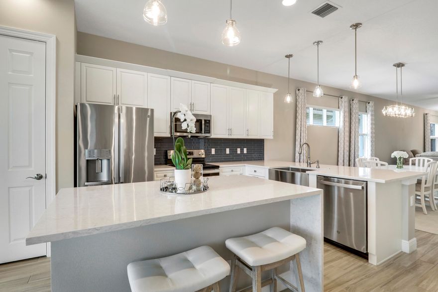 NESTLED ON A LAKEFRONT LOT and BRIMMING WITH UPGRADES, this 2BR+Den/2BA/2CG home is sure to please! The many features of this great-room style 'Casita' floorplan include glass entry front door, upgraded lighting & fans, wood-look tile flooring t/o main living areas & den, carpeted bedrooms, wood shelving in closets and much more! Entertainers will love the spacious kitchen featuring white cabinets w/ quartz counters, subway tile backsplash, apron sink, center island with pendants and waterfall edge plus dual breakfast bars! Upgraded stainless steel appliances and pantry with wood shelves! Master suite has lake views, a spa-like ensuite with dual vanities, walk-in tiled shower w/frameless glass door & spacious closet! The spare bedroom & den are located close to guest bathroom. The laundry room has cabinetry for storage and a utility sink. The two car garage is spic and span with finished flooring and plenty of room for your golf cart. Florida living is all about beautiful outdoor spaces, and this home will not disappoint! Off the great room, sliding doors open to the screened & covered paver patio which spans the full width of the home and offers plenty of room for relaxing, enjoying your morning coffee or an evening cocktail. Patio is wired for tv, so watch the game or enjoy your favorite shows all while enjoying tropical breezes and gorgeous lake views!  The backyard is fenced, so perfect for those furry family members! IMPACT GLASS WINDOWS AND DOORS!!

Verano is an amenity rich community and this home is located within walking distance to some of those fantastic amenities! There is always something to enjoy with a 27 court pickleball facility, walking paths, indoor and outdoor pools, multiple fitness centers, sauna, dog park, resistance pool, e-gym, tennis courts, social clubhouse and more!  HOA dues include basic cable, internet, alarm monitoring, lawn care, common area maintenance and access to the outstanding amenity centers.  For avid golfers, there is a cart path leading to the PGA Golf Club (membership is optional and availability varies). This community truly has something for everyone.  Call today and start enjoying all that Florida living has to offer!