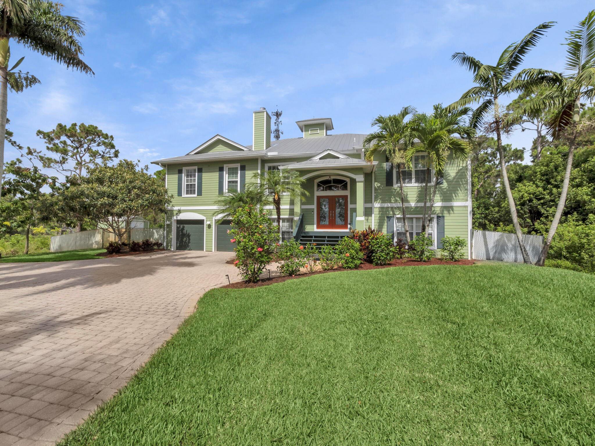 Tropical Key West Retreat on 3/4 Acre in Town!Step into your own private paradise with this beautifully updated 6-bedroom, 4-bathroom Key West-style home, nestled on a lushly landscaped 3/4-acre lot with a paver circular driveway and tropical curb appeal. This property offers the perfect blend of rural tranquility and in-town convenience.As you enter through the foyer, head upstairs to the heart of the home with an open-concept great room adorned with coffered box beam ceilings and wood-look porcelain tile floors. The newly remodeled chef's kitchen boasts quartz countertops, a center island, stainless steel appliances, and double wall ovens, seamlessly flowing into the breakfast room, formal living room, and a cozy sitting area with a newly updated fireplace.