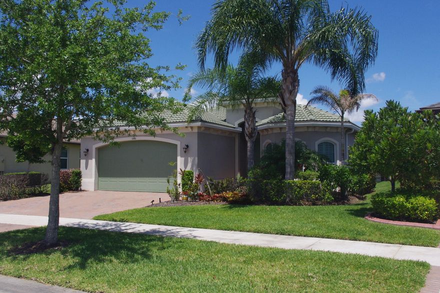 Upgraded Coastal Collection Admiral model single-family home in the desirable 55+ gated Lake Park at Tradition community!  Built in 2019 by renowned Minto Builders, this 2BDR, 2.5BA, den/office, 2-car garage, and a screen-enclosed lanai—perfect for relaxed Florida living. Outstanding curb appeal with architectural front windows, tile roof with full gutters, impact-resistant doors/windows/sliding glass patio doors, and extended paver driveway. Step inside the tall foyer to luxurious porcelain tile flooring throughout, elegant crown molding, tray ceilings, full baseboards, and recessed lighting in the great room, den, master bedroom, guest bedroom, kitchen, foyer, and garage. The open great room features a wall-mounted TV package with ceiling speakers for seamless entertainment. Custom white plantation shutters grace all windows, with verticals on the sliding glass doors. Gourmet kitchen boasts 42" upper cabinets with crown molding, a large center island with 4" under mount stainless steel sink, disposal, and dishwasher. Quartz countertops complement the GE Innovation Package stainless steel wall oven, microwave, built-in cooktop, and French door refrigerator. Convenient laundry room includes Whirlpool washer/dryer, utility sink, and upper cabinets. Enjoy low-maintenance living in this vibrant active adult community with resort-style amenities, nearby Tradition Town Center shopping/dining and easy access to beaches, golf, and healthcare. Don't miss this move-in-ready gem—schedule your private showing today!