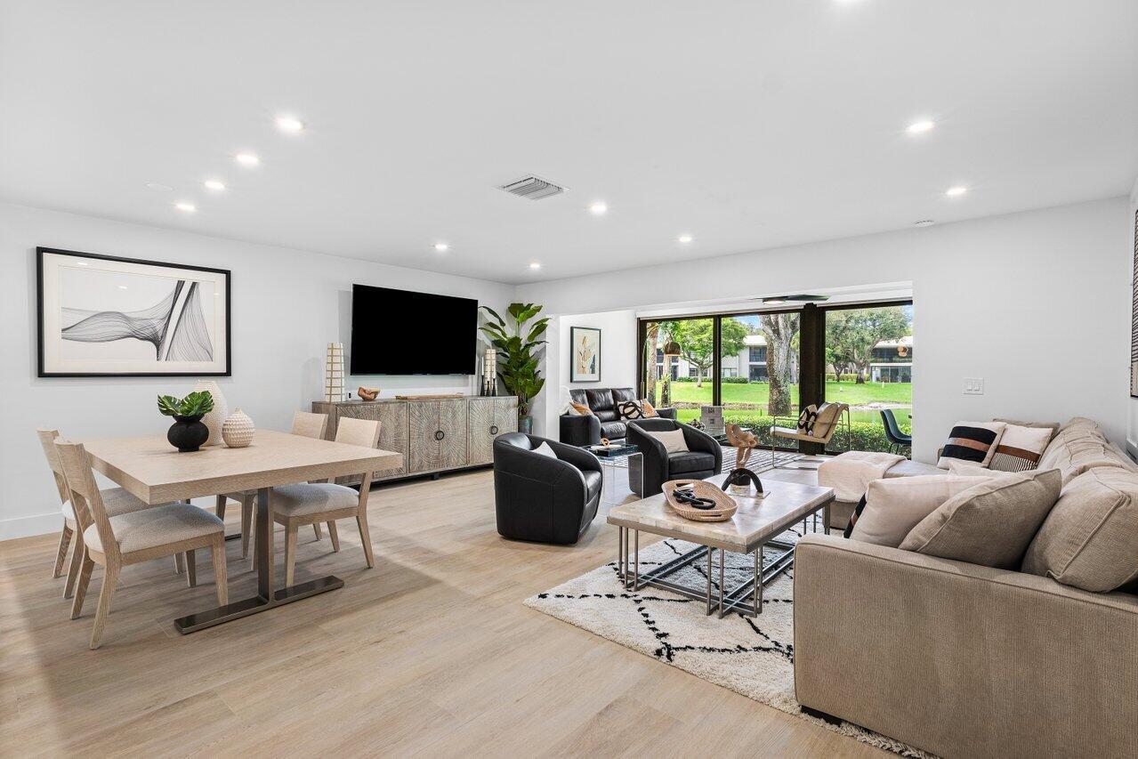 This contemporary townhouse, updated in 2022, effortlessly blends luxury with modern flair to captivate the most discerning buyers. Spanning 1,902 square feet, it offers breathtaking lake views and a thoughtfully designed open-concept layout. As you step inside, sleek wood-look tile and a designer accent wall create an inviting and stylish ambiance. The gourmet kitchen seamlessly integrates with the living area, featuring a chic powder room. Ascend to the second floor to discover a guest bedroom with ensuite bath, and the primary suite, complete with walk-in closet and luxurious spa-style bathroom. The private front patio is ideal for outdoor dining and barbecues, and the exterior features complete hurricane-impact glass protection.