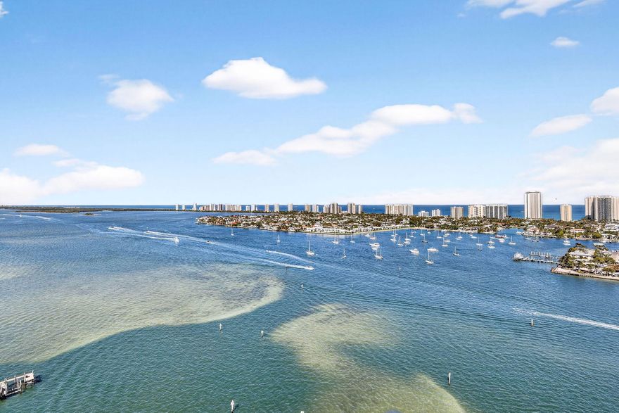 Rarely available penthouse residence at Marina Grande offering elevated luxury living with soaring 11-foot ceilings and breathtaking panoramic views of the Intracoastal Waterway, Atlantic Ocean and Singer Island. Located in the desirable 2608 stack, this exceptional sky-high condo is a rare opportunity in one of the area's premier waterfront communities.  This spacious 3-bedroom, 3-bath residence features a bright open floor plan with floor-to-ceiling impact glass and skylights, filling the living spaces with natural light and showcasing stunning views from the main living areas and bedrooms. The kitchen is appointed with tray ceilings, granite countertops, quality cabinetry, newer stainless steel appliances and ample prep space, ideal for both everyday living and entertaining. Crown  molding throughout adds an elegant touch.   Move-in ready and offered fully furnished, this home features wood flooring throughout with tile in the bathrooms creating a warm sophisticated coastal feel. The primary suite offers a private retreat with luxurious bath accommodations and generous closet spaces, while two additional bedrooms provide flexibility for guests, family, or a home office.  Additional conveniences include one assigned covered parking space, guest parking available in the garage, and a private storage cage.  Marina Grande residents enjoy resort-style amenities including a manned guard gate, community activities, fitness center, pool, spa, tennis/pickleball courts, clubhouse, billiards room, card room, and nearby onsite marina access with dry docks. Ideally located minutes from Singer Island beaches, waterfront dining, shopping, Peanut Island and the Palm Beach Inlet with no fixed bridges.   A rare penthouse opportunity—ready to enjoy immediately.