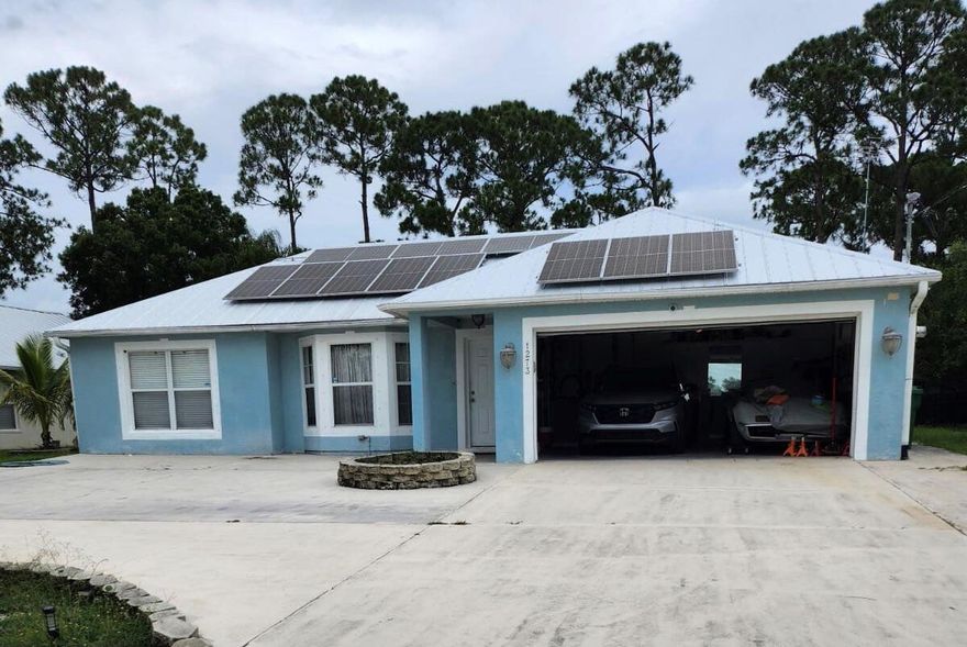 Rare 4-bedroom, 2-bathroom home with no HOA! This beautifully maintained property is packed with upgrades. Enjoy peace of mind with a new AC (2024), new water heater (2024), a new metal roof (2023) & solar panels for energy efficiency and low utility costs. Inside, the spacious layout features an inviting open floor plan and stainless steel appliances in the kitchen. Outside, you'll find a newly extended driveway offering extra parking space for guests, boats, or RVs. Assumable VA loan (subject to lender/VA approval) with a low 2.75% interest rate. This is a rare opportunity for qualified buyers to lock in low payments and save thousands! Located in a desirable area of Port Saint Lucie, close to shopping, dining, and major highways. This home offers unbeatable efficiency and value!