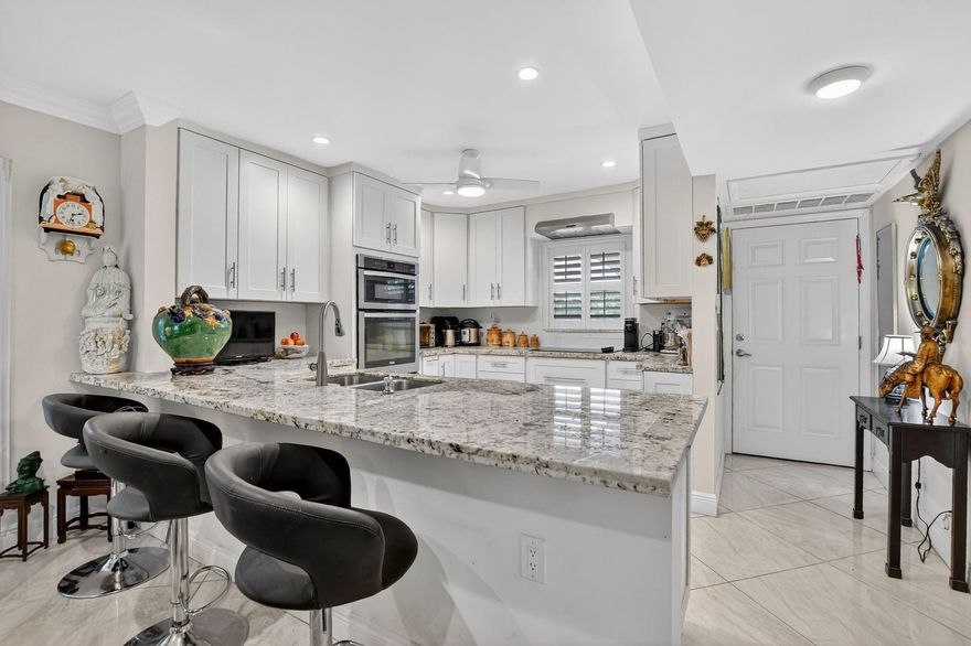 Fully remodeled 2nd floor corner unit near Dixie and Federal Highway on 20th.  Great location with shopping, dining, entertainment, and beach options all within 5 minutes.  Kitchen has been opened, connecting it to the dining   and living areas.  No popcorn ceilings!  Crown moulding throughout, beautiful tile floors, white cabinets, stainless steel appliances, impact windows and roller shades for hurricane protection, tankless water heater, and in-unit washer/dryer.  The primary bedroom has an ensuite bathroom with shower and access to the screened porch overlooking the greenspace leading to the pool.  The 2nd br is spacious and has a full wall of closets.  Parking space right at the bottom of the stairs.  Super East Boca Raton location and great location within the community too!