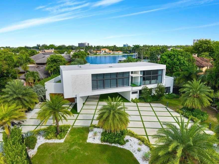 Magnificent waterfront estate in Sea Ranch Lakes, a gated home within the exclusive 24-hr guard-gated community with private beach club. Set on a 22,000+ sq. ft. lot with 80 ft. of direct Intracoastal frontage, this residence boasts lush landscaping, a resort-style pool, and expansive outdoor spaces designed for entertaining. A huge roof terrace offers panoramic water views. Inside, the flow-through plan includes 7 rooms, 5 full + 2 half baths, and an Italian imported kitchen with new countertops, built-in bar, and extendable island. Additional upgrades include a state-of-the-art facial recognition security system, outdoor kitchen with new counters and bar, master suite with custom closet, and updated garage with fridge, beverage fridge, and wall organization panels.