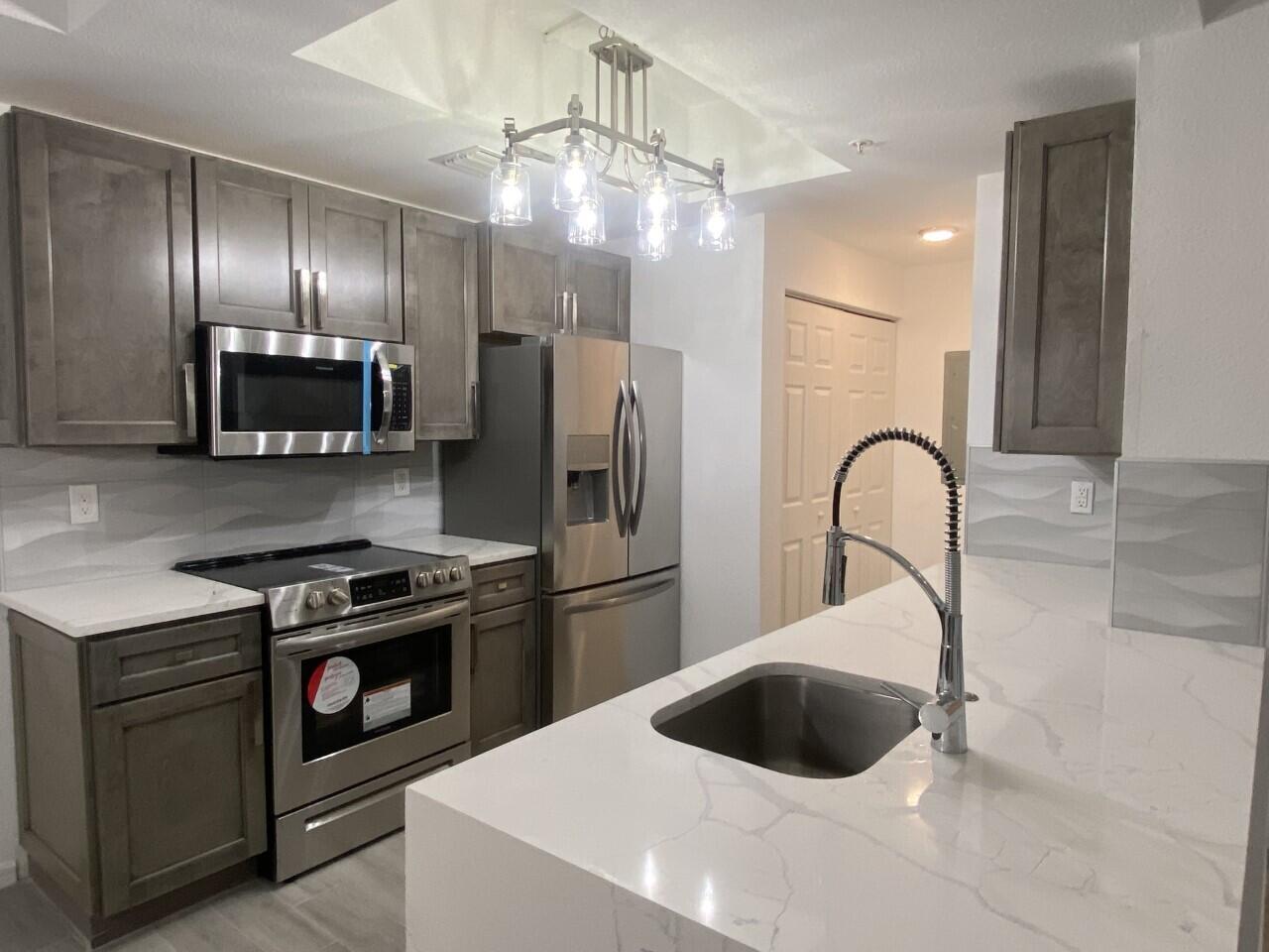 Enjoy living in this lovely, renovated first floor condo with private entrance. Updated kitchen cabinets, SS appliances, granite counter tops, kitchen island made to one level, grey ''wood look'' ceramic tile THROUGHOUT including BR's. Bathrooms with granite tops, vessel sinks, and 24'' tiled floors. Wonderful light fixtures in kitchen, dining, and bathrooms. Private entry from side of building, not from a common hallway. Split bedroom plan. Ample parking for you and your guests. San Matera has Fantastic amenities including resort style pool, fitness center, saunas, billiard room, and more. Great Palm Beach Gardens location with easy access to major roads, the Gardens Mall, Downtown at the Gardens, public beaches, the PGA corridor, and all Palm Beach Gardens as to offer. Min 650 credit.