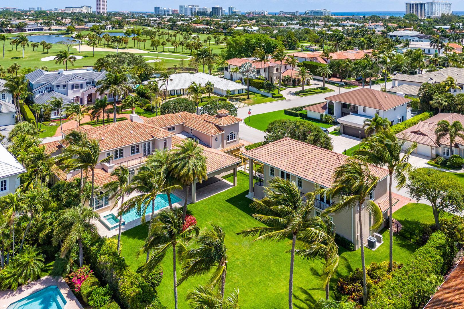 Discover luxury and privacy in this exquisite estate, set on a rare double corner lot in the heart of Royal Palm Yacht & Country Club. With over 7,000 square feet of living space, including a separate guest house, this six-bedroom, 7 full and 3 half-bathroom residence offers a harmonious blend of grand design and thoughtful amenities, making it a true assemblage for refined living. The first-floor owner's retreat is a sanctuary of comfort, featuring a recently renovated bathroom and expansive walk-in closets. Culinary excellence is at the heart of the home, with a chef's kitchen that boasts top-of-the-line appliances, custom cabinetry, and dual islands ideal for casual gatherings and formal entertaining. Step outside to your private resort-inspired backyard, where a new pool and