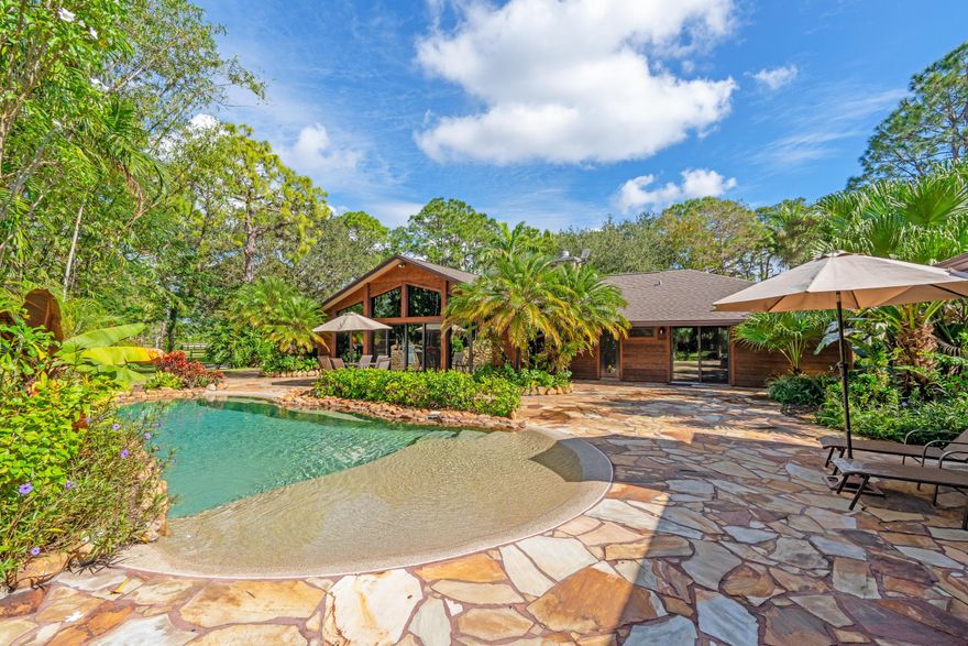 Welcome Home Welcome home to this rustic estate retreat set on 5 private acres within the securely gated community of Homeland in Wellington. Thoughtfully cared for and quietly improved over time, this property offers the rare opportunity to enjoy a home that feels like a true sanctuary, while still benefiting from modern reliability and comfort.

The main residence features 4 bedrooms and 3 full bathrooms, filled with warm character and timeless appeal. Natural wood elements, teak paneling, and exposed beams create inviting living spaces that feel grounded and authentic. Behind the scenes, the home has been maintained with attention to major systems and infrastructure, allowing the next owner to enjoy peace of mind without sacrificing the home's rustic charm.

The home opens to serene outdoor spaces designed for both relaxation and gathering. A saltwater pool and spa, expansive patio areas, and a quiet natural setting make it easy to unwind, entertain, or simply enjoy the stillness of your surroundings. The estate benefits from reliable utilities and thoughtful enhancements that support year-round living, whether the home is used seasonally or full-time.

Set on 5 usable acres, the property offers open land, mature landscaping, and a level of privacy that is increasingly rare. A barn and separate guest cottage add flexibility for horses, hobbies, visiting family, or extended stays, while the fully fenced grounds and dual water sources support both lifestyle and functionality.

Located within a manned, gated community known for its security, scenic riding trails, and equestrian-friendly environment, this home delivers a sense of seclusion without isolation. Despite its peaceful setting, the property remains just minutes from Wellington's shopping, dining, schools, and everyday conveniences.

This is more than a home, it's a place to disconnect, recharge, and live intentionally. A rare rustic Wellington estate where land, privacy, character, and thoughtful care come together to create a true retreat. May also be purchased in conjunction with the adjacent LOT 19 (RX-11161691)