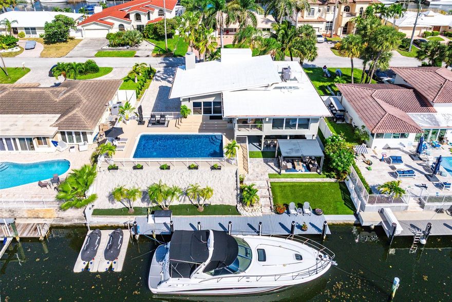 Boaters love The Cove! This waterfront retreat offers direct Intracoastal and ocean access with modern updates throughout. The open living area features vaulted ceilings, neutral finishes, and panoramic canal views, flowing seamlessly to the pool and lanai. The remodeled kitchen includes quartz countertops, stainless appliances, & access to a covered lanai shared with the primary suite, both overlooking the pool and water. Downstairs, a spacious family room opens to the patio, outdoor kitchen, & bar, ideal for entertaining. With an 80-foot dock, impact windows and doors, and proximity to beaches, dining, & shops, this home captures the best of coastal living. Over 1000 sq. ft. of outdoor living. Outdoor lighting surrounds the home for continued evening enjoyment. See Supplemental Remarks