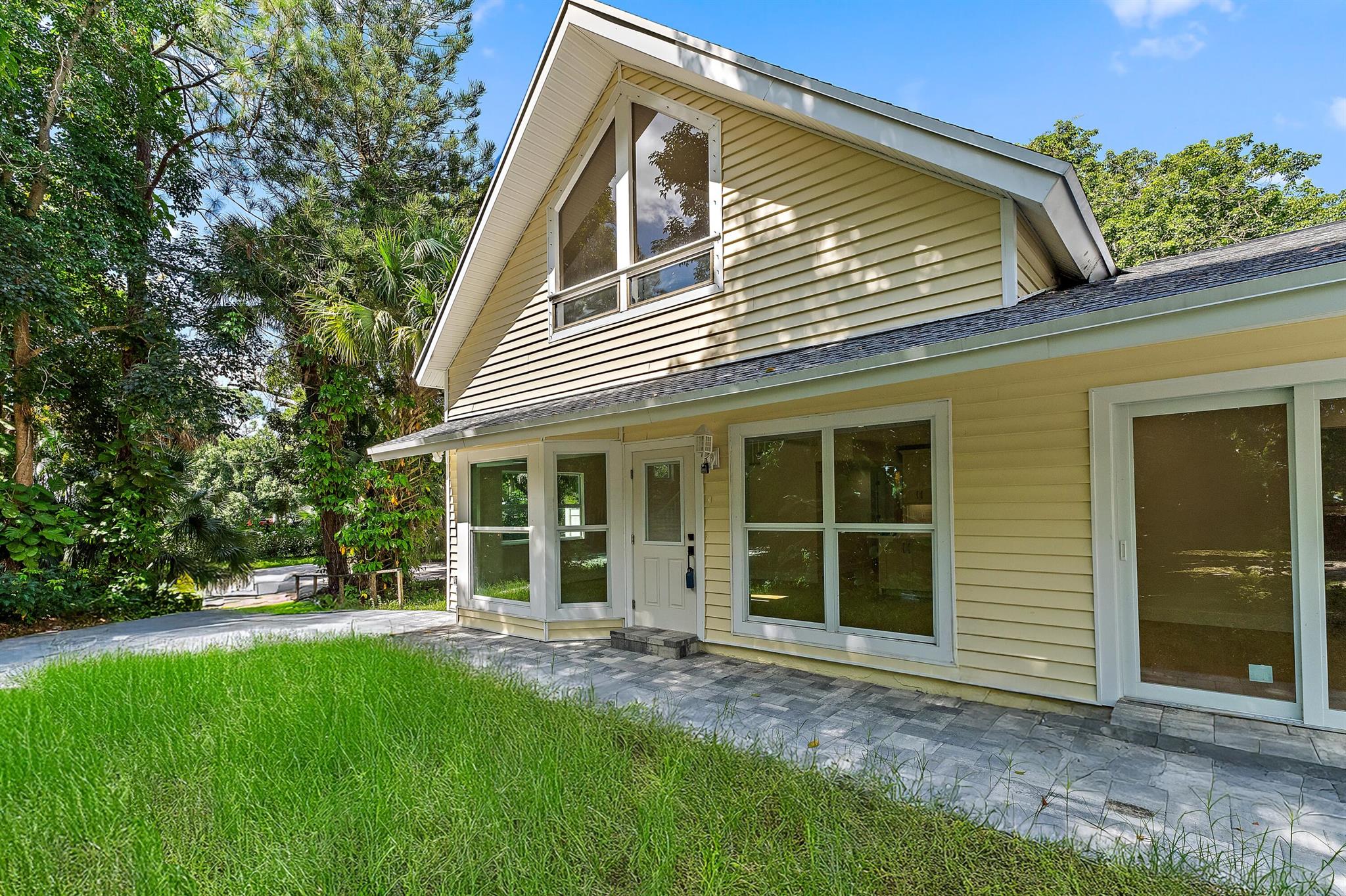 Recently updated multi-level home in Jupiter Farms with an income-producing guest house on 1.25 landscaped acres.The main home features 4 bedrooms and 2 bathrooms across nearly 2,300 sq. ft., with European white oak and tile flooring, vaulted ceilings, a large family room, and a remodeled kitchen with quartz countertops, custom cabinetry, and premium appliances. The primary suite includes dual sinks and a private balcony.The detached guest house offers 1 bedroom, 1 bathroom, and a full kitchen, currently leased month-to-month at $1,500/month, ideal for rental income or multi-generational living.Additional features include full impact protection (except the top front window), an oversized detached garage with space for vehicles and recreational equipment, a new water system