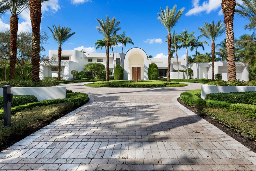 Facing west to a long stretch of waters, this   lakefront contemporary estate, reconstructed in 2007, is set back on sweeping 1.36+/--acre grounds studded with tropical trees in lush seclusion.  Lakeside window walls open the residence to coral-stone terraces around the infinity-edge Pebble Tec pool encircling a spa.  The skylit lanai is served by a high-end summer kitchen.