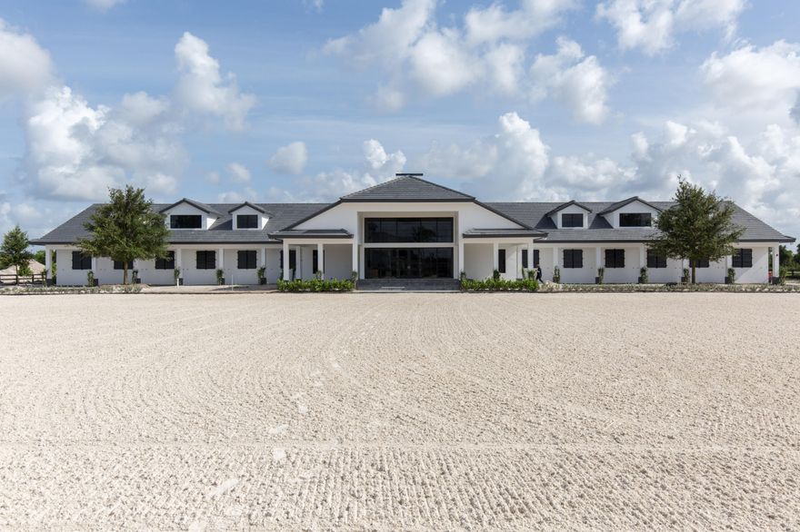 This brilliantly appointed Grand Prix Village South property is an absolute must-have. Situated on 4-acres of lush land, is an amazing 20-stall barn with 4 wash stalls, 2 tack rooms, a laundry room, and a feed room. Absolutely no expense was spared in the creation of this masterpiece. The owners' lounge has a beautiful fireplace as the focal point, as well as a kitchen with great room for entertaining and a wonderful view of the 220' x 120' all-weather ring with superior custom footing. Property also includes six paddocks and a separate grooms' apartment with 4 bedrooms and a large kitchen.