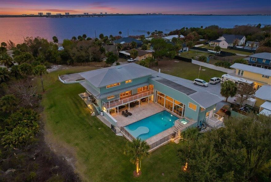 Perched high on peaceful Mockingbird Hill, this exceptional 5-bedroom, 5 full bath estate sits on 1 acre with sweeping Intracoastal water views and a versatile floor plan designed for both comfort and entertaining. The entire top floor is dedicated to a private primary suite retreat. Enjoy a modern kitchen and beautifully updated bathrooms, a cozy fireplace, a 40-foot pool with spa, and a spacious pool house featuring an entertainment room with bar that can also serve as a guest retreat or separate mother-in-law suite. The gorgeous lawn, adjacent to the preserve, creates a peaceful park-like setting with added privacy. An oversized garage, with workshop inside and boat and RV parking outside, adds rare functionality. A true Jensen Beach gem that has it all.