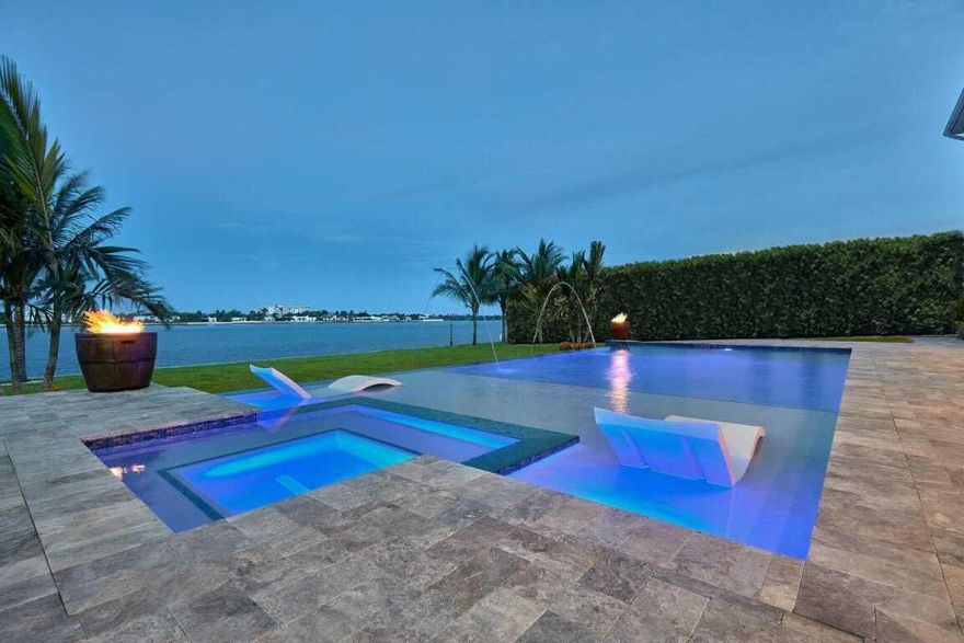 Stunning deep water property with rare wide lot layout that creates breathtaking panoramic waterfront views from almost every room! Custom craftsmanship adorns every inch of this open floor plan masterpiece! Designer features/finishes include: Custom wood board and batten paneling throughout entire home, high ceilings throughout, whole home backup generator, surgical grad air filtration throughout, elaborate reverse osmosis (RO) and carbon filtration system with 300 gallon reservoir, elevator with wood paneling, custom gourmet kitchen with high end stainless steel Thermador appliances and farmhouse sink, two master bedroom suites (one on first and one on second floor), large office with access under stairs closest to convert to sixth bedroom, custom designer lighting and plumbing fixtures throughout, Hunter Douglas electric shades on all water facing windows/doors, Plantation shutters on all inland facing windows, all smart system equipped (Ring, pool, security, electric shades, nest thermometers, surround system, etc), two separate garages (one 2 car and one single car), Bose speaker system through great area, master and back patio area, huge walk-in California closets, large covered back porch with outdoor kitchen, gas heated pool with spa, water fountains and mood lighting, high end dock with boat lift (20k lb) and double jetski lift with kayak/paddle board racks (7k lb), custom garage cabinets and ceiling storage units, fully metal fenced oversized backyard, beautiful landscape including tall clusias for privacy and so much more!! This property is a true one of a kind opportunity!