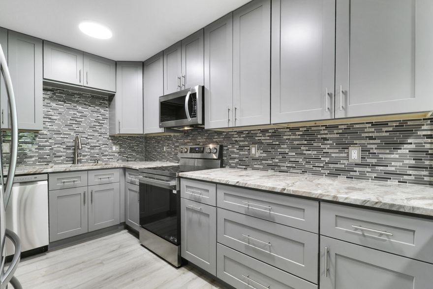 Fully renovated, move-in ready home located in the Intracoastal-front community of Royale Harbour in North Palm Beach with exclusive access to a private beach & community dock. This beautifully updated residence offers the perfect blend of modern upgrades, coastal lifestyle, & low-maintenance living in one of South Florida's most sought-after waterfront areas. Extensively upgraded, this home features a bright, open floor plan with waterproof luxury vinyl plank (LVP) flooring throughout, complete popcorn ceiling removal, & a full interior repaint for a clean, contemporary look. The fully remodeled kitchen is a standout, showcasing 42" oversized cabinetry, new granite countertops, & a full suite of new appliances. Recessed lighting with dimmers has been added throughout the home, creating a modern and inviting atmosphere. Additional upgrades include all hurricane impact windows & impact sliders with low e glass and screens, new electrical outlets & switches, updated ceiling fans, & a new washer and dryer. The primary suite has been thoughtfully redesigned with a custom closet system and a fully remodeled en-suite bathroom featuring a new vanity, mirror,  upgraded shower, & a barn door to separate it. The second bathroom has also been updated with a new vanity & mirror. Major exterior & mechanical improvements provide long-term value and peace of mind, including a new roof, gutters, mansards, & exterior paint in 2023, as well as a new HVAC system in 2020.Enjoy a private, fenced backyard with serene garden views & new landscaping—perfect for outdoor relaxation or entertaining. A rare bonus feature is the private storage closet in the carport with electricity, ideal for additional storage, a refrigerator/freezer, or hobby space.Residents enjoy direct access to the Intracoastal Waterway, including a private beach area & community dock, ideal for kayaking, paddleboarding, or enjoying waterfront sunsets. HOA dues include cable & insurance, adding convenience and value. This is a rare opportunity to own a fully updated home in a North Palm Beach waterfront community, just minutes from beaches, marinas, golf courses, dining, & shopping.