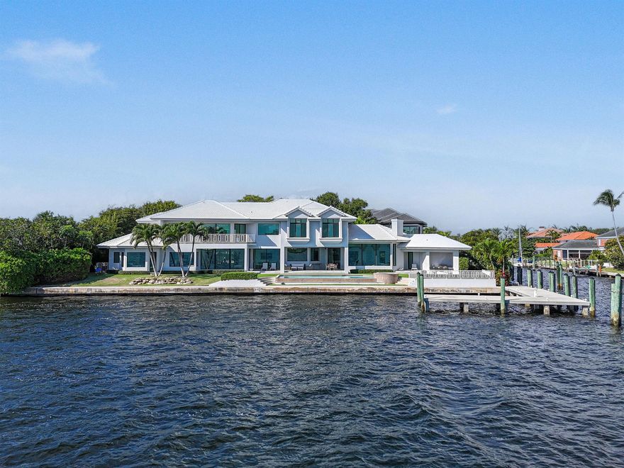 Experience the pinnacle of waterfront luxury with this exceptional estate, offering sweeping 180 panoramic views of MacArthur State Park, Munyon Island, and Singer Island. Perfectly positioned on a highly coveted .41-acre point lot, this residence showcases 219 feet of premier water frontage and captivating, wide-water vistas that span Lake Worth and the Intracoastal Waterway. Inside, the home's five bedrooms, six full baths and two half baths are designed around a bright, open-concept layout that captures stunning water views from nearly every room. The gourmet kitchen features dual islands, top-of-the-line appliances, and a seamless flow that's perfect for both entertaining and everyday living. Two primary suites offer serene retreats, each thoughtfully designed with