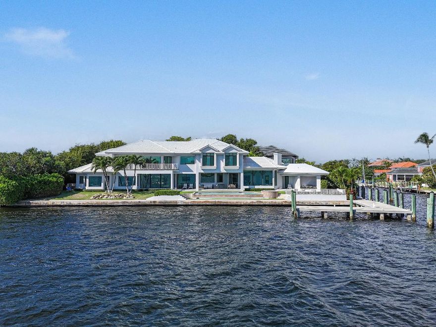 Experience the pinnacle of waterfront luxury with this exceptional estate, offering sweeping 180° panoramic views of MacArthur State Park, Munyon Island, and Singer Island. Perfectly positioned on a highly coveted .41-acre point lot, this residence showcases 219 feet of premier water frontage and captivating, wide-water vistas that span Lake Worth and the Intracoastal Waterway. Inside, the home's five bedrooms, six full baths and two half baths are designed around a bright, open-concept layout that captures stunning water views from nearly every room. The gourmet kitchen features dual islands, top-of-the-line appliances, and a seamless flow that's perfect for both entertaining and everyday living. Two primary suites offer serene retreats, each thoughtfully designed with timeless elegance, modern comfort, and breathtaking water panoramas. Each suite has an adjacent room that is suitable as an office, library or gym. Step outside to a very private resort-style oasis, complete with an infinity-edge pool and expansive covered terrace designed for alfresco dining and entertaining all set against the tranquil backdrop of the Intracoastal. A private concrete dock and bulkhead accommodates yachts up to 90 feet and provides quick, direct access to the Palm Beach Inlet ideal for the avid boater. Nestled within the prestigious Village of North Palm Beach, this property embodies the ultimate South Florida lifestyle where world-class boating, golf, and dining converge with coastal charm. A true masterpiece of waterfront design, this estate offers an extraordinary opportunity to own a piece of direct Intracoastal paradise where dramatic sunrises, golden sunsets, and passing yachts paint an ever-changing waterfront panorama.