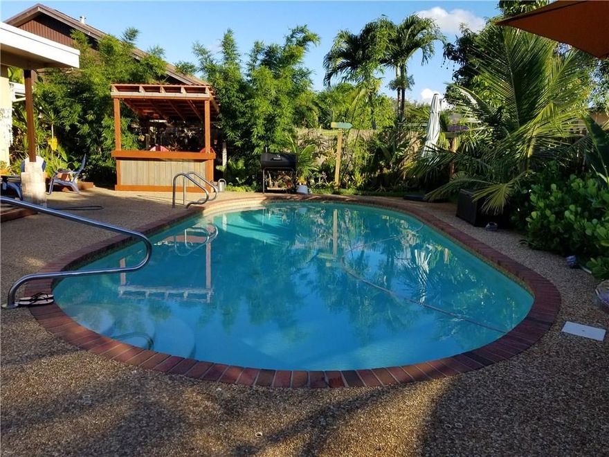 Enjoy outdoor living in this beautifully maintained 2 bedroom 2 bath Pool home, this home features a remodeled kitchen with pullout shelves and lazy susan, stainless steel appliances, remodeled cabana bathroom, marble countertop and authentic Mexican"Saltillo" tile and laminate wood floors throughout the house, wood bar, fire pit, koi pond and jungle gyman office space that can be used as a third bedroom. garage has been converted to a den with , Lush landscaped front and back yards  a tropical feel.