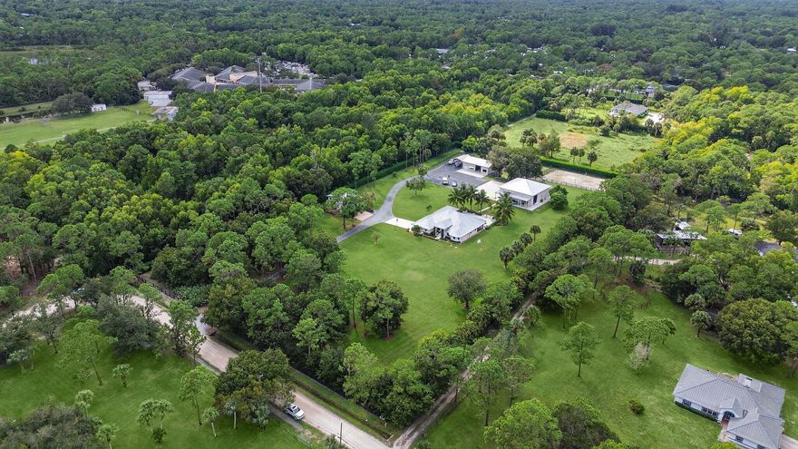 Welcome to a rare estate of distinction in the heart of Jupiter Farms 17593 Winterhawk Trail, a 5.07 acre compound built for both luxury living and legacy lifestyle. As you arrive down the private, gated and paved drive you'll immediately sense the privacy, elegance and broad possibilities of this exceptional property.   The main residence (2016 build) includes 4 bedrooms + den, 3 baths, and beautiful finishes throughout. Cozy rooms feature volume ceilings and abundant natural light from impact glass windows. The chef's kitchen is outfitted with quartzite counters, soft-close cabinetry, and a premium GE Monogram appliance package. See more... The screened and travertine decked outdoor living area with salt-water pool and fire pit is designed for entertaining under Florida's expansive skies and stunning tropical sunsets.   Complementing the main home is a two story guest house offering approximately 1,500 sf of separate living, ideal for extended family, staff or flexible use.   The equestrian and hobbyist facilities are equally impressive: a pole barn, paddocks, arena and stalls, plus a  Pole barn features approximately 2,500 sf of air-conditioned space, auto lift and multiple oversized doors for vehicles, equipment or marine craft.   Indoor Shooting Range, Set apart and sound-isolated, the dedicated indoor shooting range facility offers private, secure training or recreational shooting in the comfort of your own estate. Perfect for the discerning enthusiast, law enforcement professional, or anyone seeking a world class amenity integrated seamlessly into the property. With purpose built safety features and high end sound control, this rare in home asset elevates the property's uniqueness.  Positioned on over five acres in a no membership required setting, this compound delivers the ultimate in Florida lifestyle: luxury, equestrian and recreational amenities, privacy and possibility.
