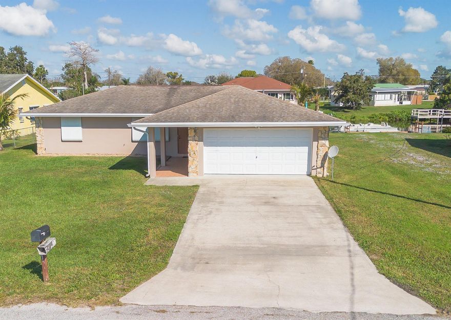 LAKE OKEECHOBEE ACCESS-TREASURE ISLAND Proudly maintained 3bd 2 ba CBS home w/1,532 sf under air & 2,113 total lvg sf.  Spacious living room with formal dining area.  Enclosed Florida room provides additional living space..   Kitchen has bkfst bar and pass-thru window to Florida room - perfect for family gatherings and entertaining.  Master bdrm has walk-in closet.  Bath has tub & separate walk-in shower.   Split floor plan. Ceiling fans throughout.  2 Car Garage has tons of storage with built-in shelving.  Storm shutters.  Backyard features a covered concrete patio overlooking canal.  Seawall & dock - 3yrs old.. Partially furnished.  Great family or retirement home. Located near cul-de-sac; so no thru traffic.  Minutes from Taylor Creek.  Make this your forever​​‌​​​​‌​‌​​​‌‌​​​‌‌‌​​‌​​‌‌​​​​ home.