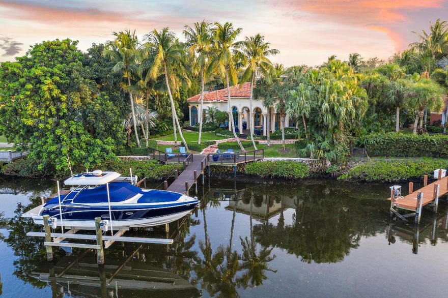 Timeless Beauty - EASY TO SHOW - This home boasts 5 bedrooms & 5.3 baths of pure elegance.  The moment you enter though the iron gates you're welcomed by lush tropical landscaping and a pool/ patio area that  feels like a resort. The chef's kitchen features gas range, white waterfall counters, large butler's pantry, bar seating all opened to the family room.  The luxurious master suites features large boutique style closets, marble bath with dual water closets, Roman style bath surrounded by a privacy garden and over sized shower, relax while taking in the view of the waterway from the seating area. 4 guest rooms each with separate private baths. 2 guest rooms are connected to a second floor living area, 2 guest suites are in the 2 story guest house that is also connected to the main house Detailed flooring and moldings, entertaining wet bar that over look the elegant living room. Protected dock with 2 lifts, water and electric all within minutes of the Intracoastal.  Come join the Admirals Cove Lifestyle.