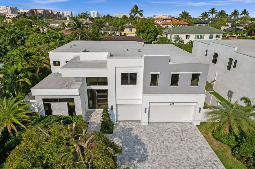 Presenting a modern, two-story New Construction gem in the enviable neighborhood of Boca Raton Riviera. With approximately 4,290 sf under air , this estate encompasses five en-suite bedrooms, an en-suite office/den , six full baths and a powder room. The primary bedroom is downstairs. The home exudes luxury living in east Boca Raton.  Located on a quiet lot, with no neighbor directly across the street. The two-story layout seamlessly combines coziness and open-concept living. The lushly landscaped property is complete with ten foot impact glass sliding doors seamlessly blurring the lines between interior and exterior. The main floor boasts a contemporary kitchen and hidden pantry that incorporate quartzite counters, custom designed cabinetry, an oversized kitchen island with plenty of