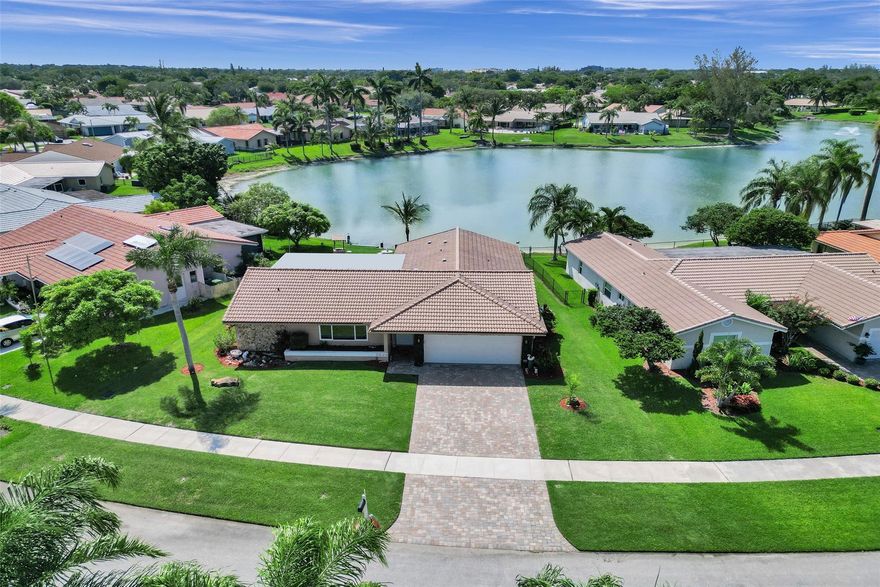 Lakefront sunsets every night! This 3-bed, 2-bath home offers peaceful water views & visiting wildlife right in your backyard. Relax & entertain year-round on the covered, screened-in patio overlooking the lake. Hurricane impact windows, sliders, & doors provide safety, comfort, & energy efficiency. Located minutes from Centennial Park & downtown Coral Springs. Inside, the split floor plan, vaulted ceilings, & natural light create a feeling of comfort. The kitchen offers extra cabinet space & buffet area, while both bathrooms have been tastefully updated. The spacious primary bedroom includes an oversized closet. Pride of ownership shines throughout with well kept landscaping. The irrigation system pulls water from the lake, helping save on utility costs. Low HOA of just $175 per year.