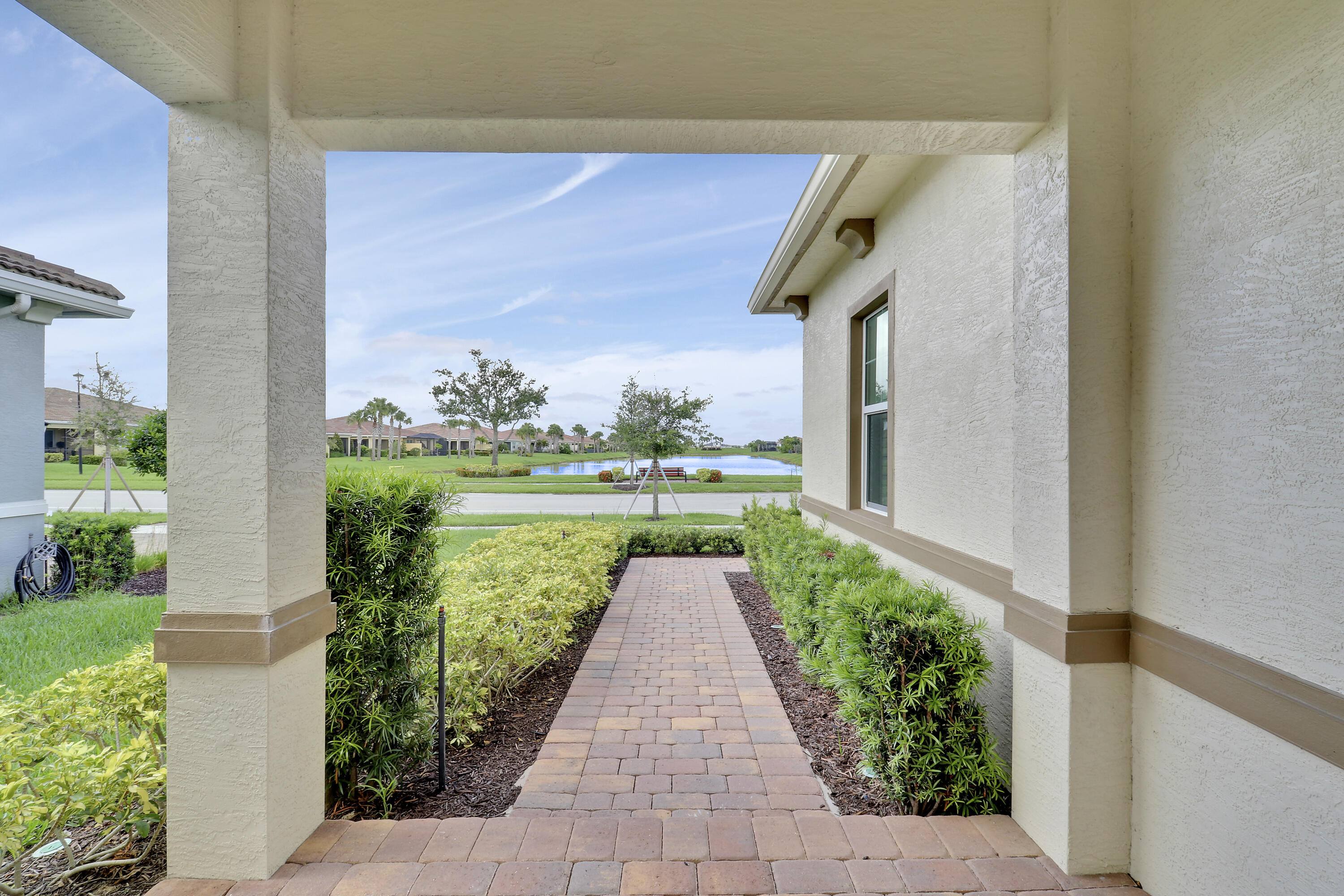 Elegant & upgraded home in PGA Verano. Enjoy the Florida sunshine in this MINT CONDITION, BETTER THAN NEW home brimming with plentiful upgrades! This 2BR+Den/2BA/2CG 'Bella' plan in PGA Verano is BARELY LIVED IN and ready for immediate occupancy.This home offers the best of both worlds. Enjoy the tranquility of a private backyard while savoring stunning lake views from the charming front porch, kitchen, and casual eating area. Meticulously maintained and used only as a vacation retreat, has ensured like new conditions throughout. The property is loaded with upgrades. Interior features include wood-look tile flooring in living areas, wood flooring in bedrooms, den and closets, plantation shutters t/o, impact glass windows and doors, screened and covered patio and tray ceilings.
