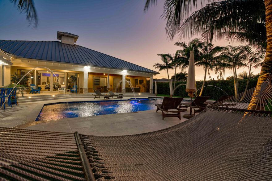 Incredible value at this stunning, modern estate home on 100' of waterfront has it all! Designer finishes and fully furnished. Salt water pool with spa and jets.  One of the best ''NO HOA'' streets in PBG, wide/deep salt water canal. No fixed bridges & easy ocean access. This newer premier estate home has 5 bedroom, 5.1 bath plus office, 3 car garage, impact glass 24KW generator, 24K boat lift. Tiki bar, outdoor kitchen, oversized covered living/dining with motorized screens.  Gourmet gas appliances. Open concept with no detail left undone.  Walk through this Mahogany door into a spectacular foyer with wood tray ceiling and salt water fish tank.  Master bedroom plus 3 additional en suite bedrooms plus office in the main house and separate 1/1 guest house/casita.