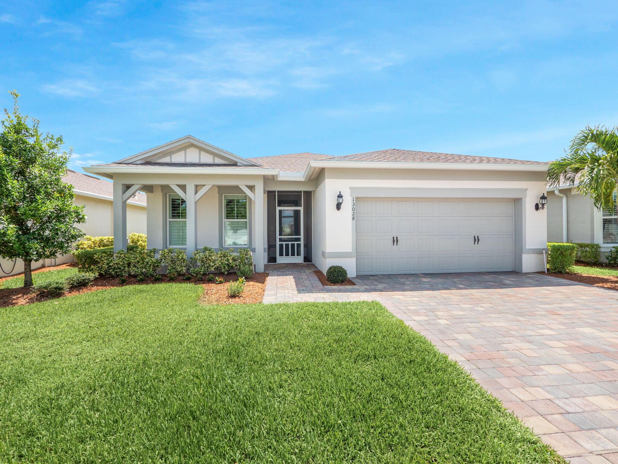 Lakefront Luxury in Del Webb at Tradition! This beautifully appointed 2-bedroom + den, 2-bath home offers peaceful east-facing lake views and a highly upgraded interior designed for comfort and style. Step inside to wood-look tile flooring throughout, quartz countertops, upgraded kitchen package with gas cooktop, and custom closet built-ins. French doors enclose the den, perfect for a home office, media room, or guest overflow. Enjoy custom plantation shutters, bamboo blinds, under-cabinet lighting, LED living room package, and a glass-insert front door for extra charm. The spacious Mud/Laundry room includes new washer/dryer, cabinetry, utility sink, and a walk-in storage closet. Outside, unwind on the screened patio, take in the sunrise over the lake, or enjoy the fully fenced yard!