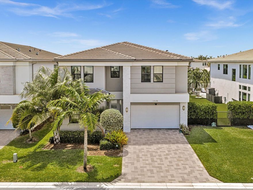 Located steps from the clubhouse, this lakefront pool home is filled with custom finishes and includes the furniture. This upgraded Polynesia model features a dramatically upgraded kitchen with a massive oversized island, premium Thermador appliances, high-gloss cabinetry, added storage beneath the island, and a rare Thermador refrigeration wall with touch-to-open refrigerator, freezer, and wine storage.  The two-story living room makes an immediate impression with soaring ceilings, glass stair railings, and a glass second-floor overlook that creates a clean, modern architectural feel. Hardwood flooring starts at the stairs and continues throughout the second floor, adding warmth to the home's contemporary design.   The primary suite features two separate primary bathrooms and two ultra-luxurious walk-in closets, each finished with high-end custom cabinetry, soft-close drawers, thick solid doors, glossy finishes, and exceptional built-in organization.  Additional upgrades include luxury custom closet systems throughout the home and solid European-style interior doors, adding another level of quality and finish.  Outside, enjoy a lakefront pool, raised jacuzzi, covered patio, and peaceful water views. With the furniture included and major custom upgrades already completed, this home offers a rare move-in-ready opportunity in Lotus.
