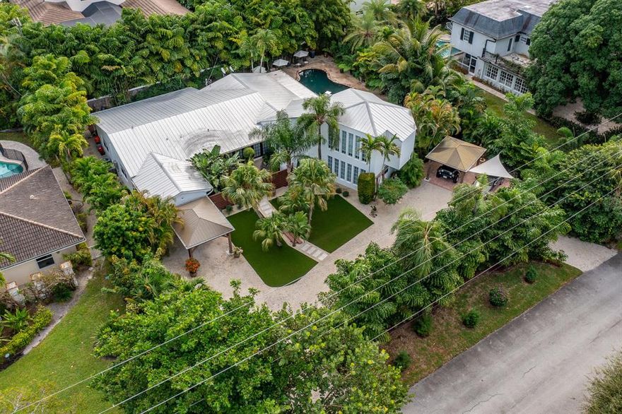 A Totally Unique Must-See Single-Family House in Lake Ida, Delray Beach.
This may be the most interesting single-family house in the Lake Ida district, close to downtown Delray Beach. As you enter the property, you are immediately awestruck by the well-maintained front yard, with a large circular driveway that offers complete privacy as it is hidden behind a giant hedge. Here you will find a garage, and two carports with lots of additional parking spaces. Then as you approach the main entry, you'll see an antique privacy gate that leads to a courtyard with a real Japanese Zen feel. 
Once you enter the house, your foyer consists of a long hallway which in one direction leads to the living area and kitchen, and in the other direction to the bedroom quarters. You will from the beginning appreciate the solid hardwood white-painted floors that flow through the entire house, as is the case with the ceilings. Yes, this is true Florida charm at its best! The living room consists of a large open floor space with a fireplace in stone, and a staircase that leads to a separate loft which the current owners use as a TV/music room. The vaulted ceiling with wood beams makes for a dramatic, impressive, and open bright feeling with twelve vertical elongated windows, which brings natural light into the entire living space, including the kitchen which is located on the opposite side of the living room.
The kitchen itself is modern with white shaker-style cabinets and gray colored quarts countertops, and it has an island with seating for four people that is perfect for entertaining. You'll also appreciate the large commercial grade gas stove with a real exhaust hood to the outdoors, as well as the oversized refrigerator. 
The backyard is like a little private hidden oasis with marble pavers, a Japanese inspired water fountain, exotic plants and Japanese bonsai trees, a natural lagoon-looking swinging pool, not to mention a gazebo area where you can hang out come rain or shine. This resort-like paradise practically wraps around the entire house.
And just wait until you see the large master bedroom with its own private outdoor area and oversized shower. This house is unique in all aspects of the word!