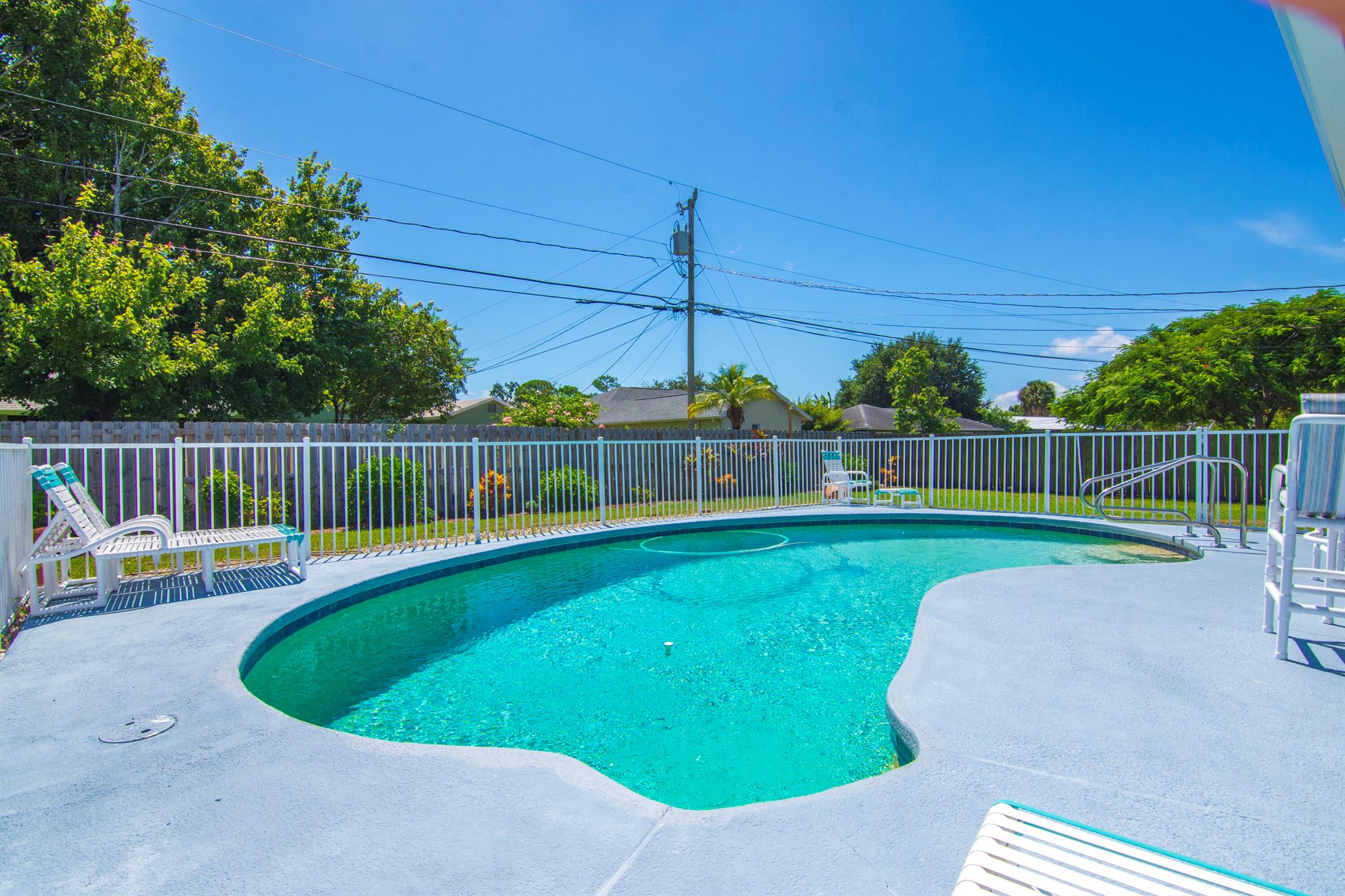 Welcome to this beautifully updated pool home located at 2858 SE Rawlings Rd in Port St. Lucie. This home has been thoughtfully improved with major upgrades, offering both style and peace of mind. Recent updates include a 2024 HVAC system, a 2023 roof, and a 2023 fence, ensuring comfort and value for years to come. The exterior features a new poured concrete driveway and professional landscape curbing, giving the home excellent curb appeal from the moment you arrive.Step inside to find a bright and open floor plan with neutral tile flooring throughout the main living areas, creating a clean and modern feel. The living room flows seamlessly into the dining area and updated kitchen, perfect for everyday living and entertaining. The kitchen has been upgraded