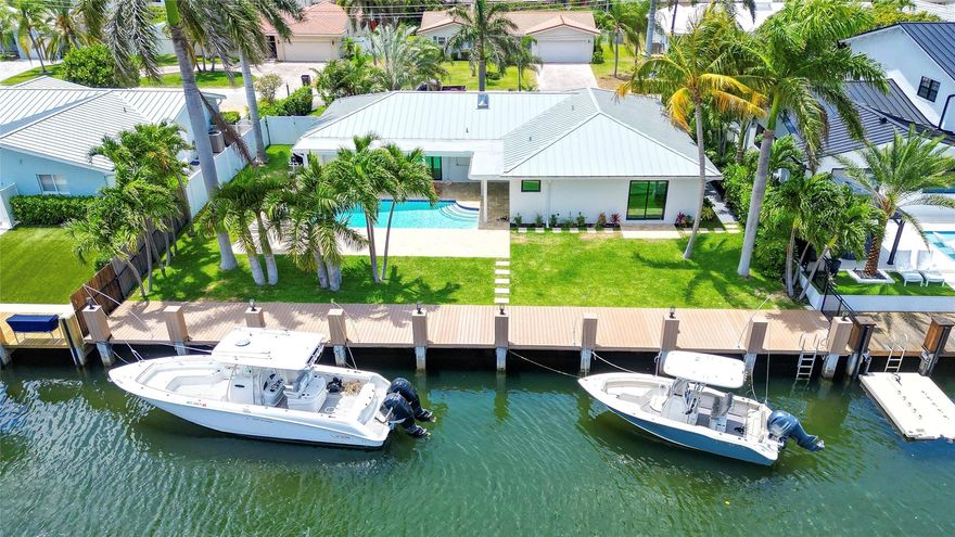 Fully remodeled 3-bed, 3-bath waterfront home with 90 ft of dockage on the North Grand Canal—just minutes to the Intracoastal & Hillsboro Inlet. Features include Marvin impact windows/doors with pocket sliders, wood grain porcelain tile, new ducting, full electrical upgrade, new PVC plumbing, skylight, and a new metal/flat roof. The elevated composite dock is built on concrete pilings with water, electric, and lighting. Interior boasts Thermador appliances, oversized quartz island with waterfall edges, custom wet bar with wine cooler, built-in closets, indoor laundry, and spa-inspired baths with floating vanities, LED mirrors, and rainfall showers. Enjoy a resurfaced heated pool/raised spa, large round driveway, and walking distance to Dan Witt Park. Bring your boat, or two!