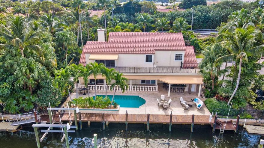 Boater's dream! Updated, move in ready home with 140'' of waterfrontage 1 lot off the point. 90'' dock, lift, jet ski pad, & paddle board /ramp/launch. Enormous backyard ideal for entertaining: heated pool & spa, cabana bath, expansive pool deck & lanai, & summer kitchen/bar. Gorgeous water views. Fantastic location for a quick cruise to the Boynton inlet & a few blocks walk to the beach, restaurants, shopping. Interior highlights include wood burning fireplace, marble & wood floors, vaulted ceilings, 120 bottle Liebherr wine fridge & Wolf gas range. Owner's suite features two spacious walk-in closets w/ built-ins, spa bathroom, and ICW view terrace that spans the length of the home.  FULL IMPACT WINDOWS & '22 HOUSE GENERATOR. Deep 3 car garage with height for lifts. Paradise found!