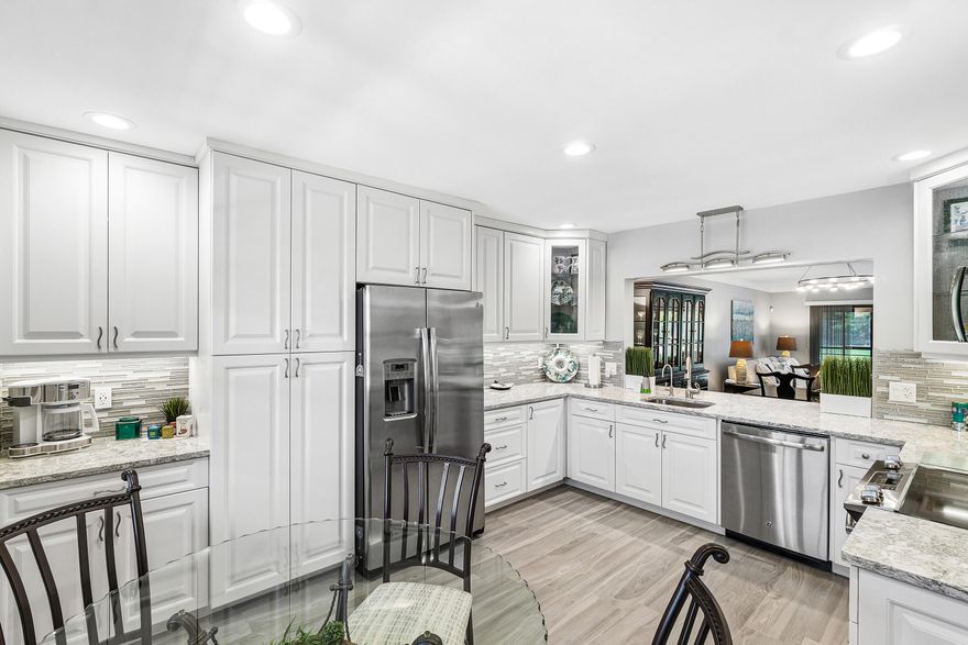 Impeccably renovated and HURRICANE PROTECTED, this spacious move-in ready, 2-bedroom, 2-bath split-bedroom condo features a completely updated White kitchen showcasing premium Cambria quartz countertops, CUSTOM WOOD SOFT-CLOSE CABINETRY, with pull-out shelves, and glass display cabinets, STAINLESS-STEEL APPLIANCES and Pentair water filter.  Sleek gray WOOD-LOOK PLANK PORCELAIN TILE flooring throughout. Bathrooms completely updated with beautiful porcelain tile and all new wood cabinetry and fixtures.  PGT HURRICANE-IMPACT WINDOWS throughout and ACCORDIAN SHUTTERS on the enclosed lanai provide complete hurricane protection, interior sliders open to one side completely opening the living room to the lanai. HUNTER DOUGLAS window treatments are top-down, bottom-up insulated cellular shades and commercial grade vertical blinds.  New ELECTRICAL PANEL (2022) and all new switches/outlets, A/C system (2016) with a platinum carbon air filtration system (2024).    Located in Aspen Glen section of guard-gated Indian Spring community, provides long lake and golf course views with a calming east/west exposure to enjoy beautiful sunsets on the lanai. A truly fantastic opportunity to start enjoying the Florida lifestyle year-round or seasonally.