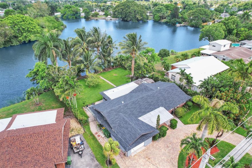 No HOA ***TROPICAL OASIS**Waterfront Property ****Great house in Palm Springs! Enjoy an oversize backyard on the lake. Room for a POOL, BOAT and and RV. Living Florida life surrender by coconut trees. House shows as a 5 bedroom with 2 full bathrooms. Spacious living room and dining area. Original kitchen, large finished screen porch, entrance finished open porch, 2021 roof, circular paver driveway to park 4 cars, AC from 2018, 7k water filter system for the entire house.  Hurry to see this house... it won't last! As per floor plan shows in Photos (produced by the photografer) house shows as 1,533 SqFt under Air. The original garage has been converted into a bedroom ( has central AC), but can be converted back. As per seller, no flood insurance necessary. Buyer to verify all information.