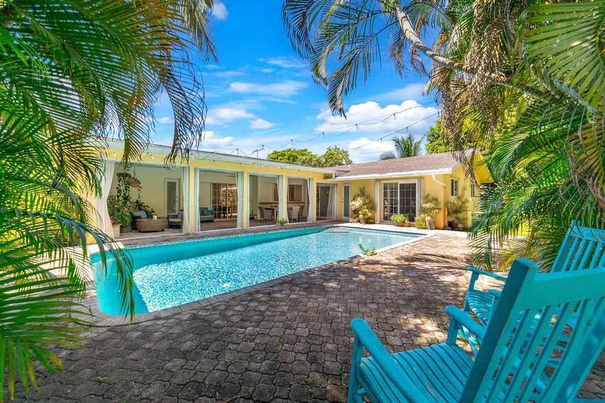Welcome to this 4-bedroom, 2-bath pool home in Royal Palm Estates, offering 2,118 sq. ft. of relaxed living. Updates include an upgraded electric panel, a new paver driveway, PVC plumbing, Underground 500 gallon leased propane tank, partial impact-resistant windows with shutters, and new water heater. The kitchen features upgraded appliances, including a newer stove, microwave, and refrigerator. A two-car garage with EV charger adds convenience. The backyard is a tropical retreat with a saltwater pool, patio, mature plants, and waterfront views. Sprinklers are fed from the canal, which greatly reduces the expenses for water, and no brown stains from well water. Inside, flooring includes LVP, tile, and original terrazzo that could be restored throughout.