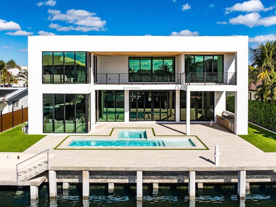 Now complete and move-in ready, 750 NE 69th Street is a striking modern waterfront residence located in Boca Harbor, Boca Raton's premier boating community, offering quick and direct access to the Boca Raton Inlet. This 5-bedroom, 5.5-bathroom estate features 85 feet of deep-water frontage, no fixed bridges, and coveted southern exposure, delivering an exceptional waterfront lifestyle. A dramatic floating staircase, accented by an artistic statement feature wall, creates an immediate architectural impact. Interiors are finished with wide-plank European oak flooring and enhanced by an extensive designer lighting package, including illuminated onyx countertops, LED strip lighting accenting ceiling details, and custom wall inlays that create a warm, architectural glow throughout the home. The modern European kitchen is designed for both form and function, featuring Thermador appliances, a built-in wine cooler, and an impressive double-island layoutperfectly complemented by the home's ambient lighting design.

The first-floor clubroom/guest suite is thoughtfully designed with custom wood paneling and a concealed hidden door, offering a sophisticated and flexible space ideal for guests, a private lounge, or media room.

The primary suite is a private retreat, highlighted by a spa-inspired wet-room shower, premium Hansgrohe fixtures, and expansive walk-in closets. All closets throughout the homeincluding the primaryhave been professionally built out, providing exceptional storage and organization. All additional bedrooms are ensuite, ensuring privacy and comfort for family and guests.

Outdoors, enjoy true South Florida waterfront living with a heated pool and in-ground spa, enhanced by turf accents and luxury landscaping, all overlooking the serene waterway. A brand-new concrete dock with power and water completes the offeringideal for accommodating large vessels and embracing Boca Harbor's premier boating lifestyle.

Just minutes from Boca Raton's beaches, dining, and premier amenities, this newly completed estate delivers modern design, superior craftsmanship, and an unmatched boating lifestyle.