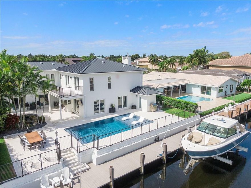 Attention Boaters! This tastefully remodeled home is located on an island street minutes from both Hillsboro and Boca inlets! No Fixed Bridges! An 80 foot composite dock with 2- 30/50 amp power pedestals & a 20,000 lb. lift. The home features automated lighting, thermostat, remote blinds, new metal roof, completely renovated pool - patio,  whole house generator and a 700 gallon Koi pond! The kitchen features a large seamless quartzite island with storage, Bosch appliances and unique custom flip out windows. The secondary bedrooms are en-suites with custom walk-in closets. Enjoy the steam shower, jetted tub, the mini refrigerator & a glass of wine in the Primary suite while taking in the views from the balcony! So much more!