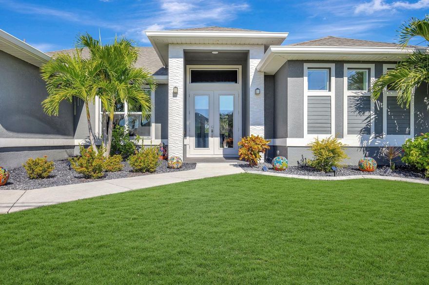 Modern design meets true Florida relaxation in this 2021 pool home offering style, comfort, and privacy. The open layout features tray ceilings, tall doors, recessed lighting, and wide sliders that brighten the space. The kitchen includes a large island, stainless appliances with hood vent, single-basin sink, dry bar, and ample cabinetry. The split-bedroom plan offers a sleek pool bath and guest rooms with tray ceilings. The primary suite features two walk-in closets, a soaking tub, dual floating vanities, and a tiled shower with dual heads. Outside, enjoy an electric-heated pool with glass tile, screened lanai, and versatile deck framed by a Calusa hedge. Impact windows/doors, a three-car garage, irrigation, and HVAC servicing add peace of mind.