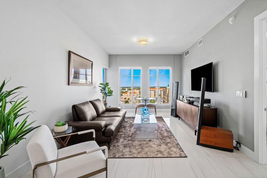 Experience captivating northeast ocean and sweeping northwest city views from this impeccably appointed 11th-floor corner residence in the heart of downtown Boca Raton. This well-appointed 2-bedroom, 2-bath condo at Tower 155 is perfectly positioned above Mizner Park, offering an effortlessly walkable lifestyle with premier dining, boutique shopping, the beach, and daily conveniences just steps away. Refined interiors feature dramatic floor-to-ceiling windows, soaring 10-foot ceilings, sophisticated Italian porcelain flooring, bespoke custom cabinetry, modern appliances, a temperature-controlled wine refrigerator, and an elegant open-concept living and kitchen design crafted for both comfort and style.