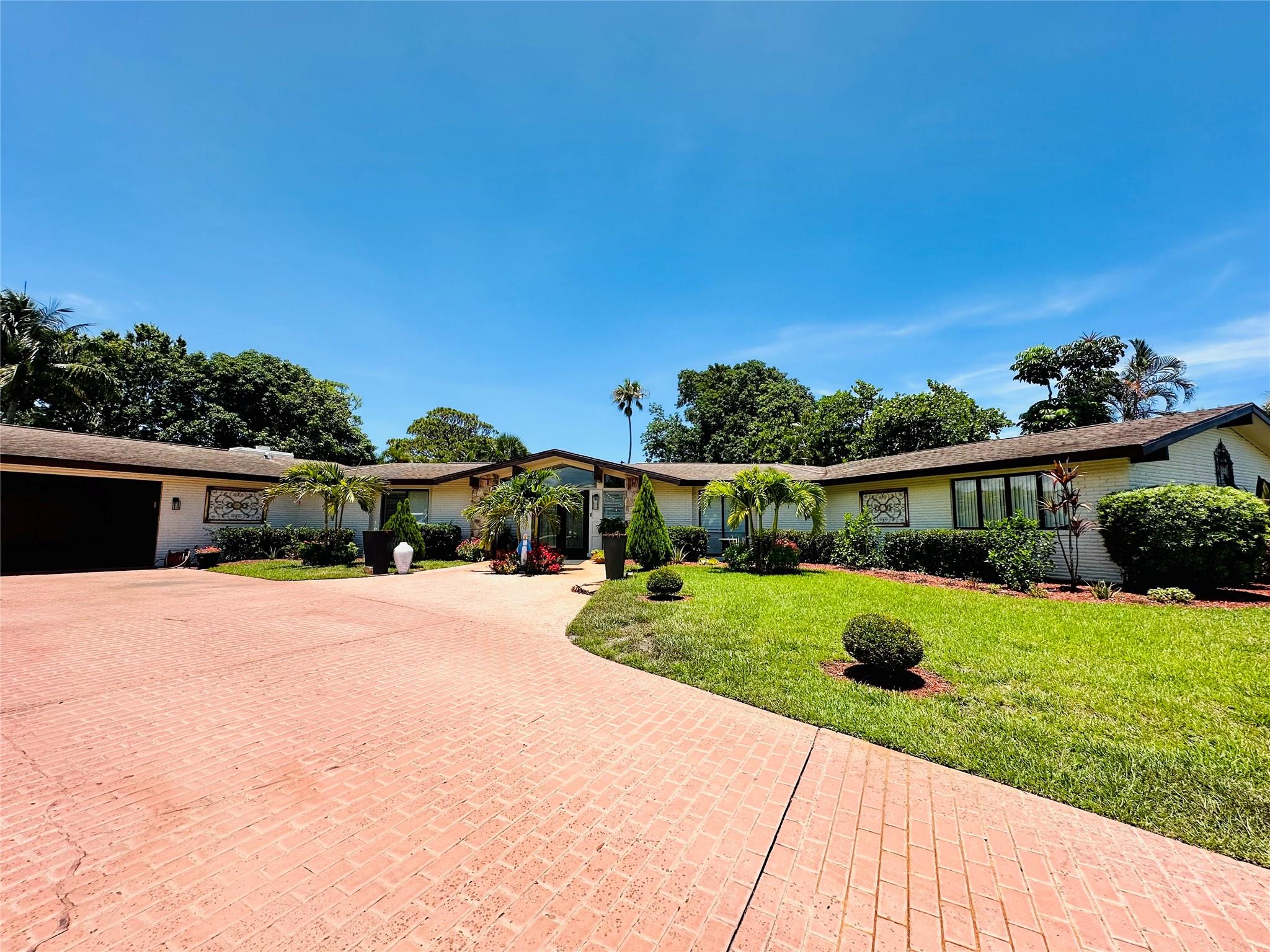 LOCATION! Situated on a spacious corner lot in one of Port Saint Lucie’s most desirable neighborhoods, this stunning home offers golf course views across the street and NO HOA restrictions. The interior features hardwood floors, French doors, a custom kitchen with granite countertops and stainless steel appliances, plus an elegant double-door entry. The remodeled primary bathroom is a true highlight, showcasing a large, custom-designed walk-in shower with premium finishes that create a spa-like experience. The family room includes a cozy fireplace, designer lighting, and a custom bar, perfect for entertaining. Designed around a resurfaced oversized pool, the home is filled with natural light from multiple sliding doors and windows, all overlooking the inviting outdoor area. Must to see!