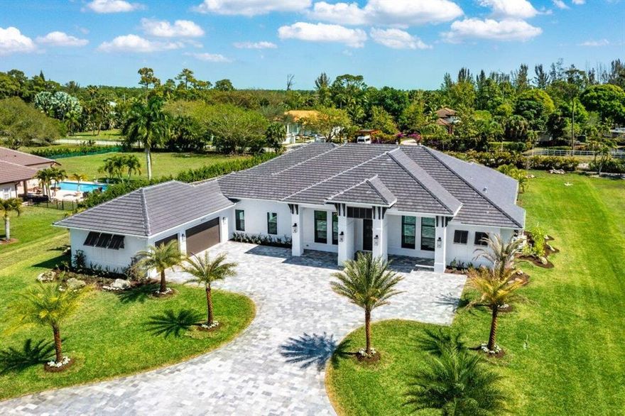 Situated on 1 acre, in the highly desirable boating and water ski community of Banyan Lakes, this custom built NEW CONSTRUCTION home combines sophisticated design, elegance and contemporary finishes. Built with superior attention to detail and boasting over 4,600 sq ft of under air living space, the home features 5 bedrooms, 4.5 bathrooms, an office/den plus an additional flex room with a multitude of possibilities! Upon entering through your custom made mahogany doors into the foyer, you will be greeted with direct views of your outdoor oasis. The soaring ceilings and oversized 12'x 70' white oak rectified tile flooring provide an exceptional and unique elegant backdrop for the natural light that shines throughout the entire home.