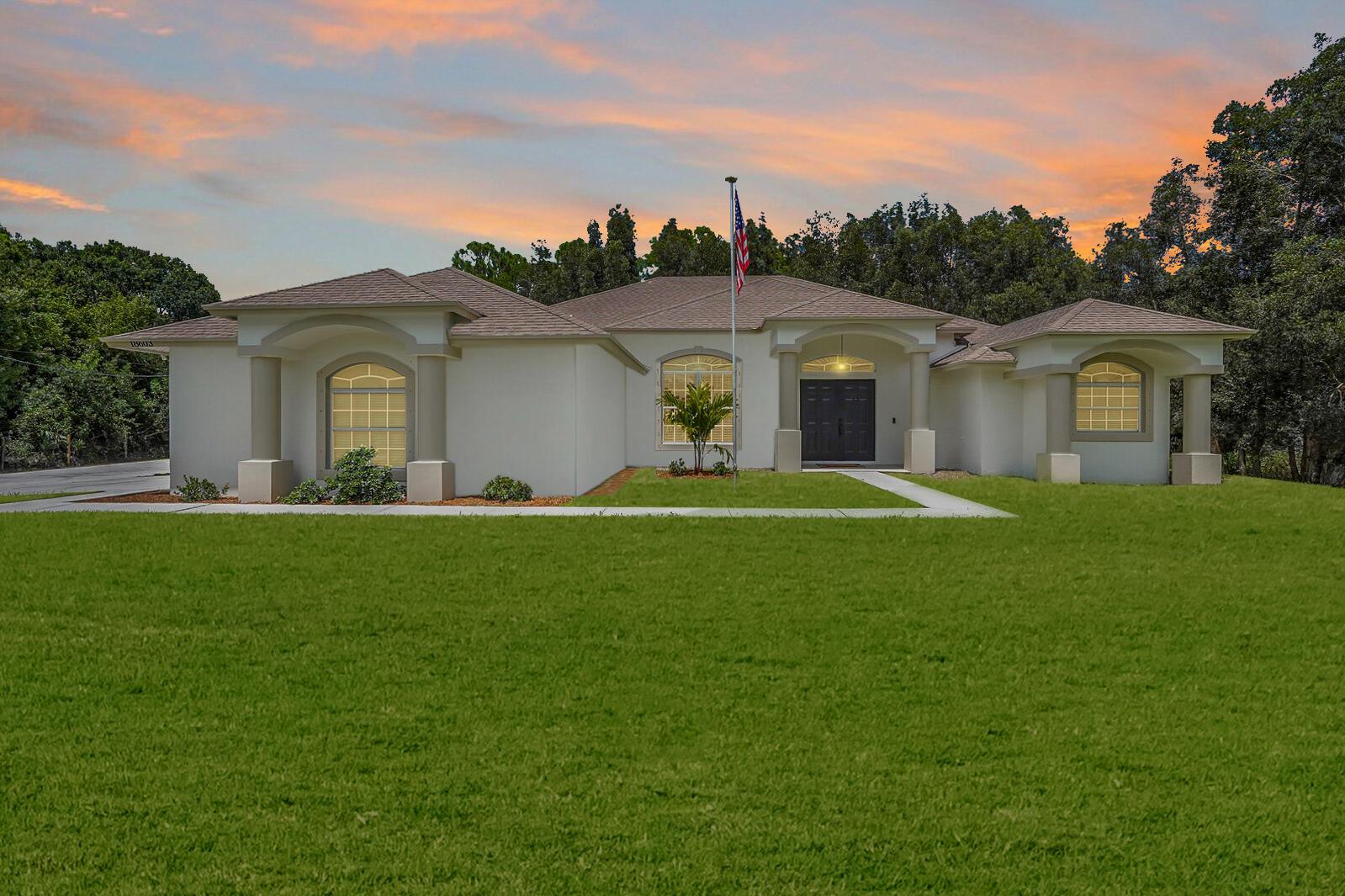 Sensational One-Level Home with Large Fenced Lot on Paved Road, Expansive Screened Patio, and HUGE Detached Building/Workshop with Car Lift! Picturesquely situated on a 1.15-acre fenced-in lot, this 3BR/2BA, 2,400sqft residence offers a tranquil vibe with a sprawling lawn, beautiful backdrop of mature trees, and a serene pond. Newly painted with neutral paint, the refreshed exterior captivates with a stucco facade, elegant Mediterranean architecture, and an inviting covered entrance. Step through the double frontdoors to discover a voluminous interior featuring high vaulted ceilings, arched doorways, recessed lighting, built-in shelving, gorgeous wood flooring, and a cozy family room.